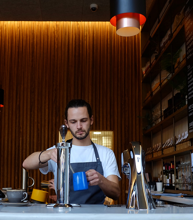 barista making coffee in shop